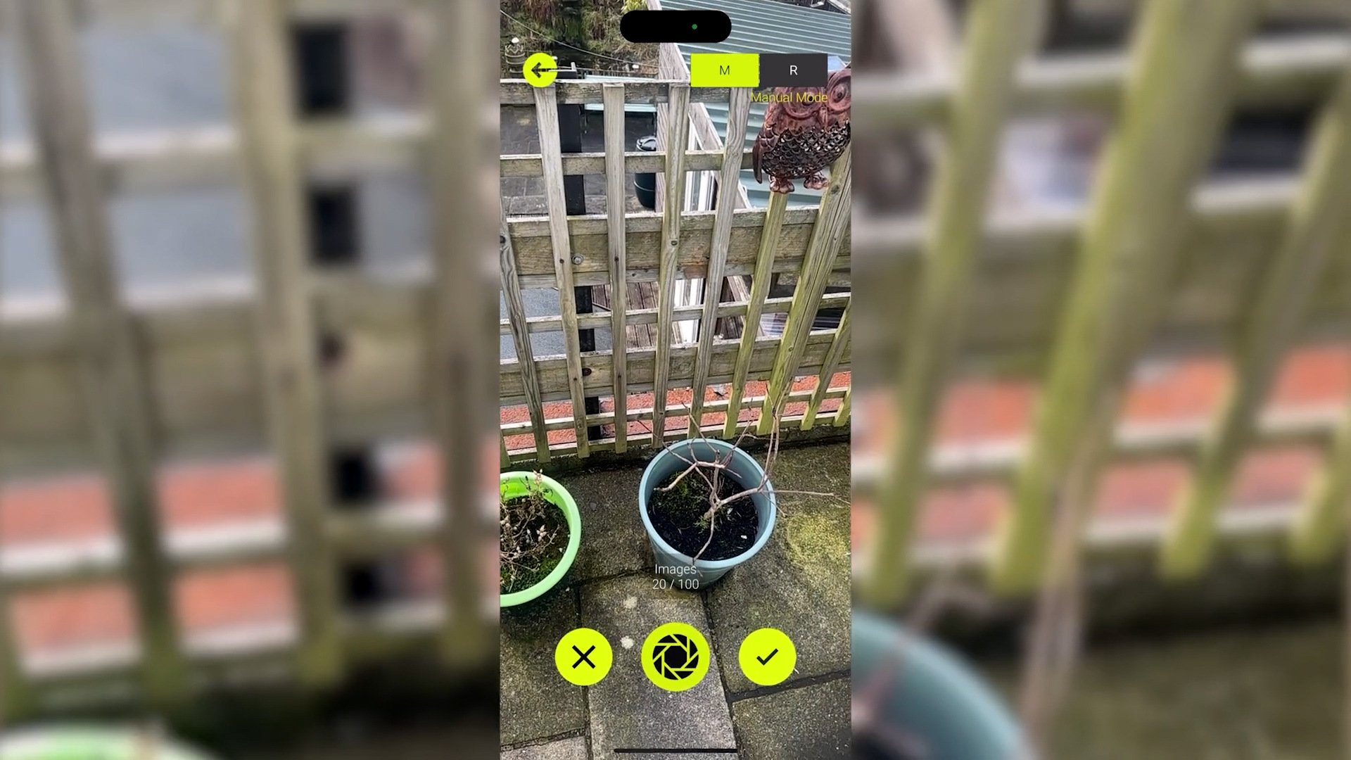 A mobile AR scanning interface capturing an outdoor garden space, with yellow UI elements for image capture and confirmation.